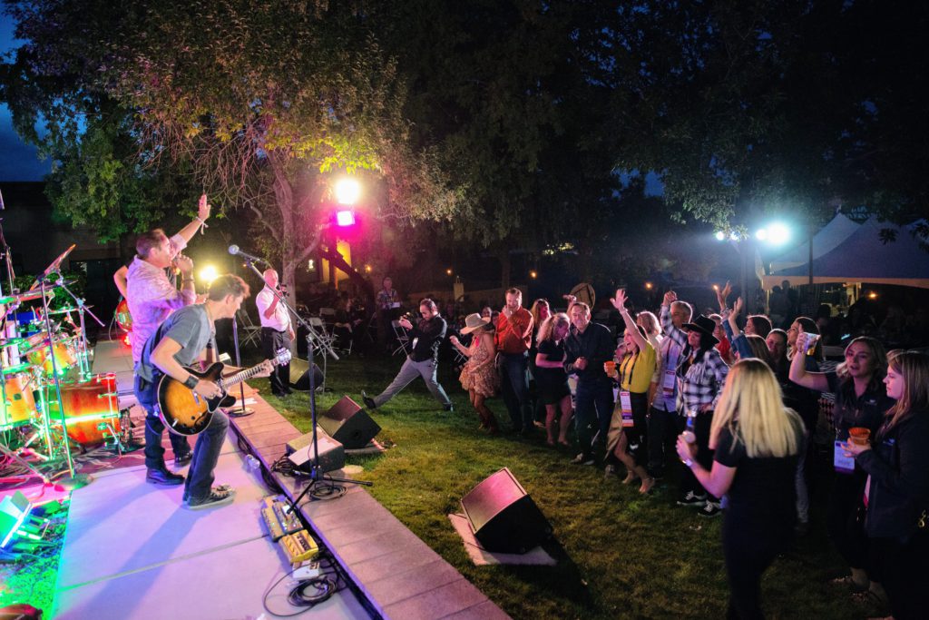 Image of Sonic Shakers performing on an outdoor stage for a crowd at the IAPA conference